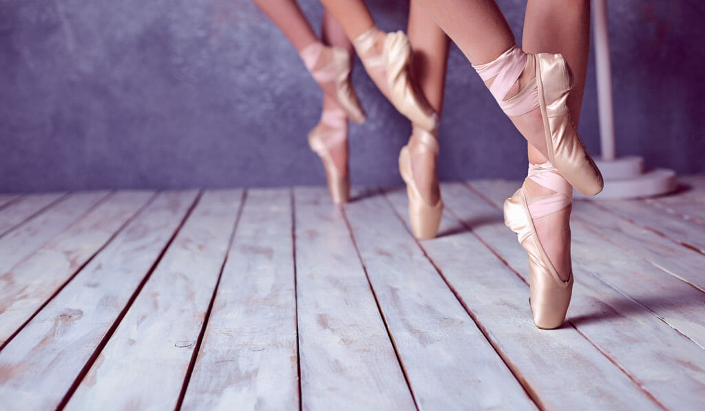 The feet of a young ballerinas in pointe shoes